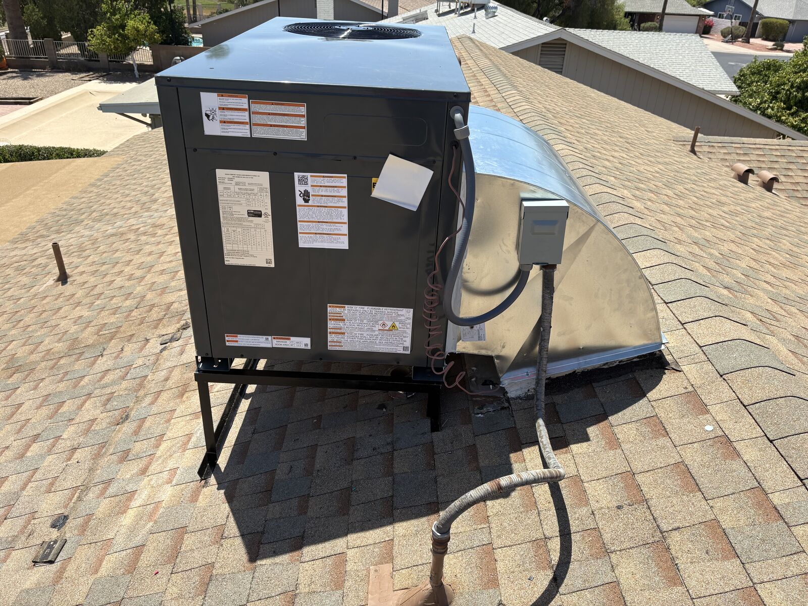 Rooftop package unit mounted on a new stand with clean gas and electrical connections in an East Valley neighborhood